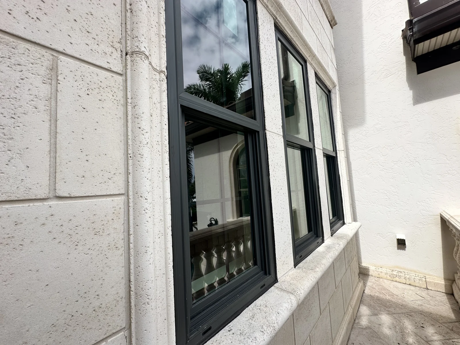 Dark-framed exterior windows set into a light stucco wall.